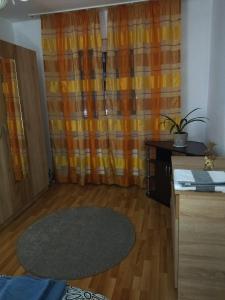 soggiorno con tenda arancione e tavolo di La Han a Făgăraş