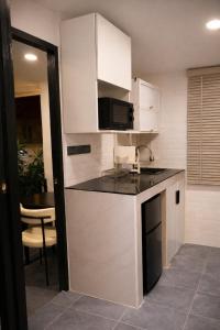 パーイにあるANNKAMii INNの白いキャビネットと黒いカウンタートップを備えたキッチン