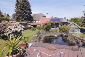 een huis met een vijver in de tuin bij Ferienwohnung bei Familie Keil in Colditz