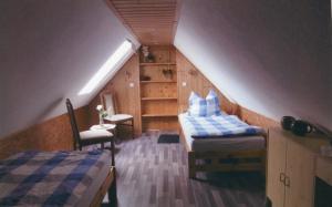 een zolderkamer met 2 bedden en een tafel bij Ferienwohnung bei Familie Keil in Colditz