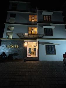 a building with a sign that reads i a wet inn at La Mer Inn in Kozhikode