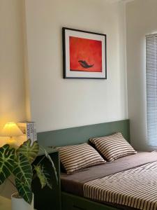 胡志明市Hera House l Vinhomes Grand Park的卧室里有一张床，墙上挂着一幅画