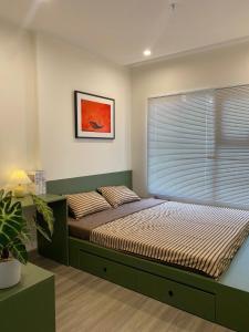 胡志明市Hera House l Vinhomes Grand Park的一间卧室，配有一张大床和一扇窗户。
