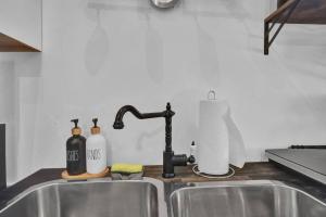 - un évier de cuisine avec un robinet et des bouteilles dans l'établissement Spacious 1 bed 1 bath Apt Close to Downtown and Beach, à Cobourg