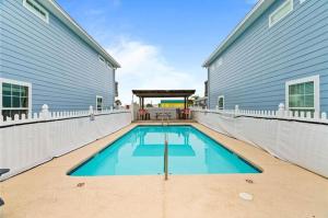 a swimming pool on a patio next to a building at The Beach Peach in Port Aransas