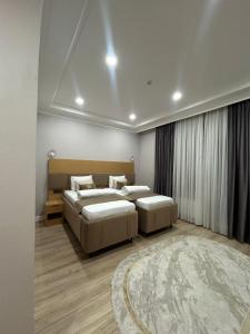 a bedroom with two beds and a rug at Tour House in Tridtsatʼ Let Kazakhstana