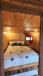 a bedroom with a bed in a wooden cabin at Cabana Pinolera in Boga