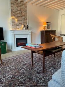 een woonkamer met een tafel en een open haard bij 123 Honfleur in Honfleur