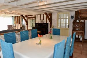 een eetkamer met een witte tafel en blauwe stoelen bij La cheneraie in Mano