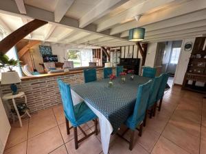 een eetkamer met een tafel en blauwe stoelen bij La cheneraie in Mano