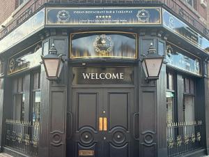 ein Willkommensschild auf der Vorderseite eines Gebäudes in der Unterkunft Empress Boutique Hotel Suites in Mexborough