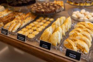 a display case filled with different types of pastries at Hotel Pedra Negra Gov. Valadares in Governador Valadares