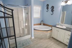 a bathroom with a tub and a shower and a sink at Beachfront Home with Huge Deck in Bolivar Peninsula +27 photos