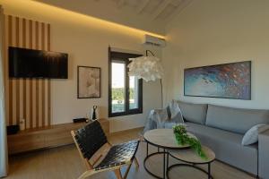 un soggiorno con un divano e un tavolo di HELIOS - Seaside Pool Villa & Private Parking a Olympiakí Aktí