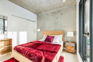 a bedroom with a large bed with a red blanket at Spacious and Stylish Modern Condo in Calgary in Calgary