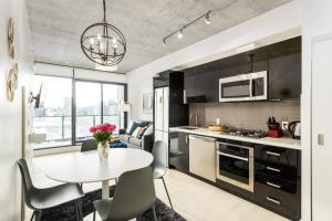 a kitchen and living room with a table and chairs at Spacious and Stylish Modern Condo in Calgary in Calgary