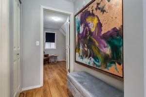 a hallway with a large painting on the wall at Cozy getaway for exploring Canmore and Banff in Canmore