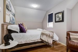 a bedroom with a bed with a table and a chair at Cozy getaway for exploring Canmore and Banff in Canmore