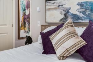 a bedroom with purple pillows on a bed at Cozy getaway for exploring Canmore and Banff in Canmore +18 photos