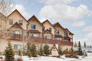 a large house with snow in front of it at Cozy getaway for exploring Canmore and Banff in Canmore