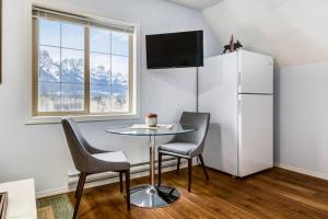 a dining room with a table and chairs and a refrigerator at Cozy Mountain View Condo Close to DT Canmore in Canmore