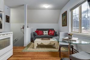 a living room with a couch and a glass table at Cozy Mountain View Condo Close to DT Canmore in Canmore +27 photos