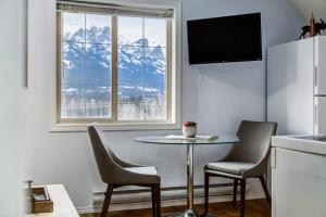 a small kitchen with a table and chairs and a window at Cozy Mountain View Condo Close to DT Canmore in Canmore
