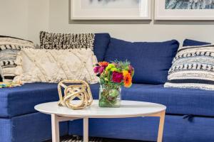 a blue couch with a vase of flowers on a table at Delightful 2BR Mountain Escape in Canmore in Canmore