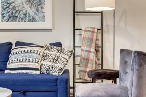 a living room with a blue couch and a chair at Delightful 2BR Mountain Escape in Canmore in Canmore +23 photos