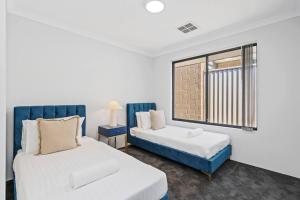 a bedroom with two beds and a window at The Sunlit Expansive Hideaway in Alkimos