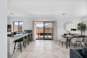 a kitchen and living room with a table and chairs at The Sunlit Expansive Hideaway in Alkimos