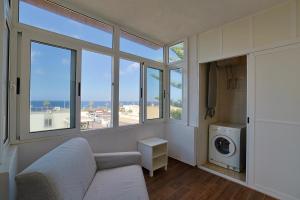 een woonkamer met een bank en een wasmachine bij SeaView Escape with Pool Access in St Paul's Bay