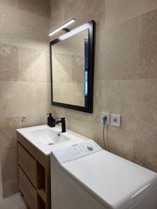 ein Badezimmer mit Waschbecken und Spiegel in der Unterkunft Le prestige - Charmant T2 neuf avec Terrasse in Évreux + 4 Fotos