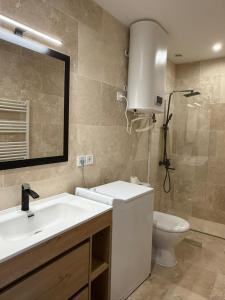 ein Badezimmer mit Waschbecken, Toilette und Spiegel in der Unterkunft Le prestige - Charmant T2 neuf avec Terrasse in Évreux