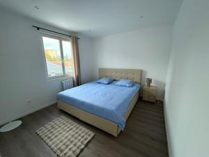 ein Schlafzimmer mit einem blauen Bett und einem Fenster in der Unterkunft Le prestige - Charmant T2 neuf avec Terrasse in Évreux