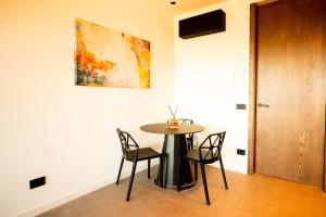 a table and chairs in a room with a painting on the wall at Sicilias in Catania