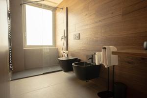 a bathroom with a black toilet and a sink at Sicilias in Catania