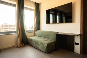 a room with a chair and a tv and windows at Sicilias in Catania +7 photos