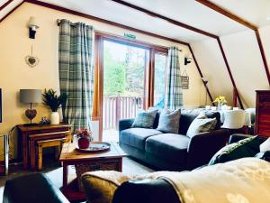 a living room with a blue couch and a window at Ericht Holiday Lodges in Blairgowrie