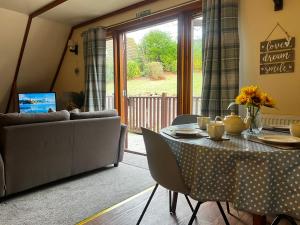 una sala de estar con una mesa y un sofá en Ericht Holiday Lodges, en Blairgowrie