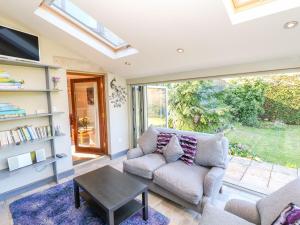 een woonkamer met een bank en een tafel bij Peters Lea in Youlgreave