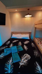 a bedroom with a bed with a black and white blanket at צימרים סוף העולם 2 in Ein Kinya