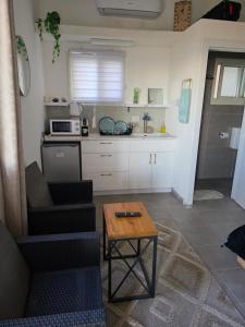 a living room with a table and a kitchen at צימרים סוף העולם 2 in Ein Kinya