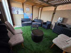 a living room with chairs and a table and a couch at צימרים סוף העולם 2 in Ein Kinya