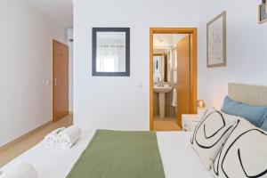 a bedroom with a white bed and a bathroom at Cabanas Beach T2 in Cabanas de Tavira +29 photos