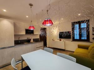 a kitchen and living room with a white table and red lights at Maison Josephine in Aosta