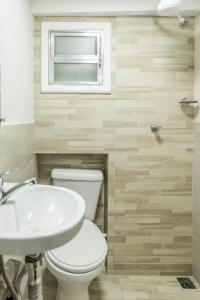 un bagno con un water, un lavandino e una finestra di Studio Romântico a Volta Redonda