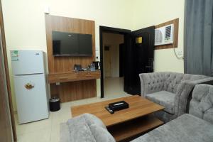 un soggiorno con divano e frigorifero di منازل الحساء للشقق الفندقية a Al Hofuf