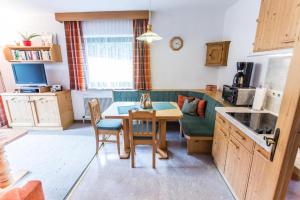 a kitchen with a table and a green couch at Appartement SONNENGLÜCK by MoniCare in Leutasch