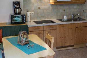 a kitchen with a table and a sink and a counter top at Appartement SONNENGLÜCK by MoniCare in Leutasch